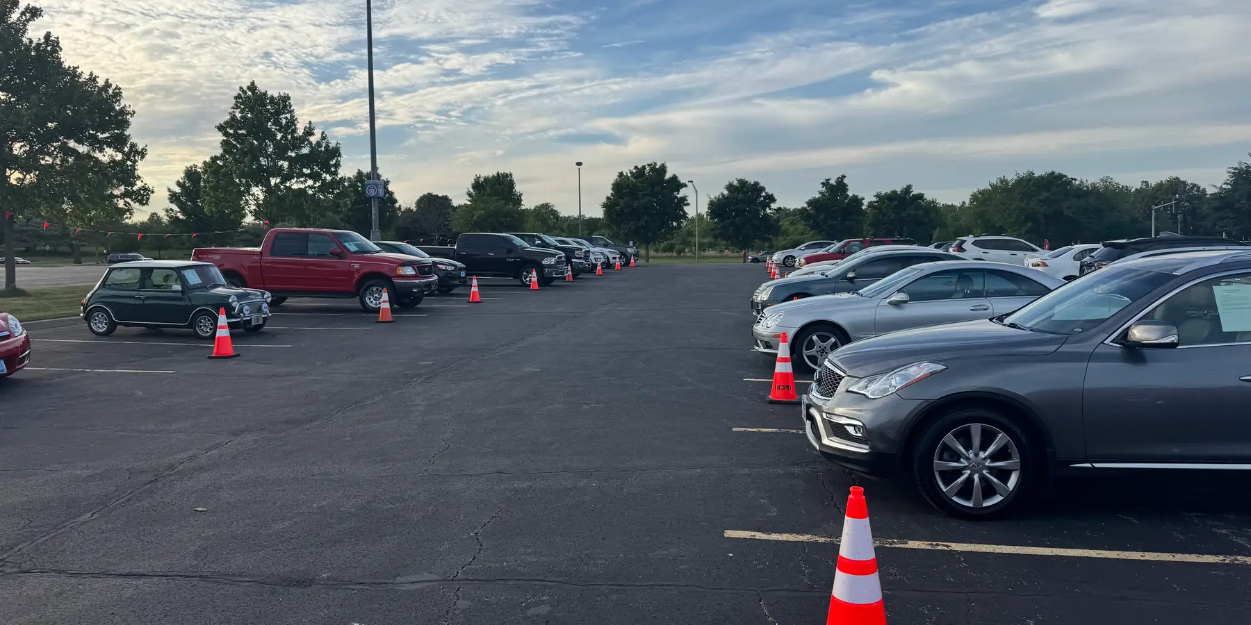 A long row of cars lined up for sale on the lot at Event #1