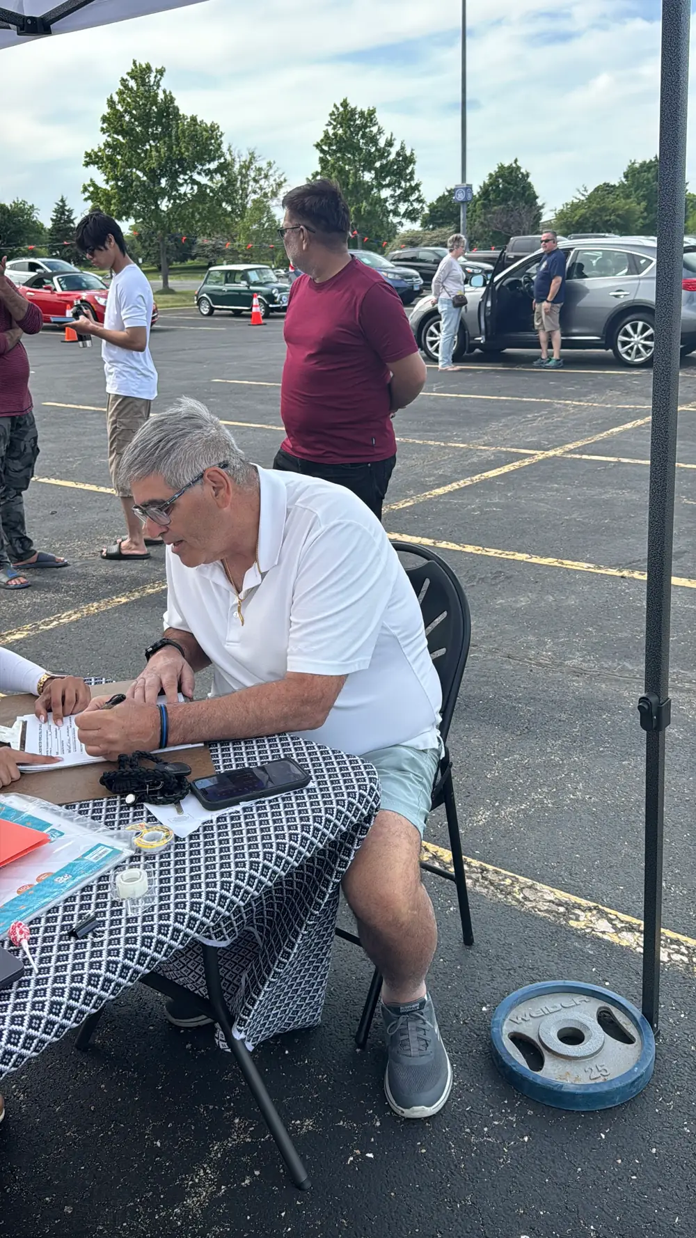 A seller signing sale paperwork at the Chicagoland Auto Fair booth