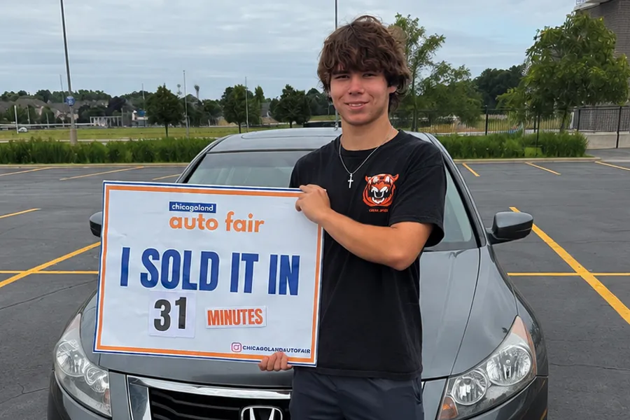 A seller holding an I sold it in 31 minutes sign with their Honda Accord