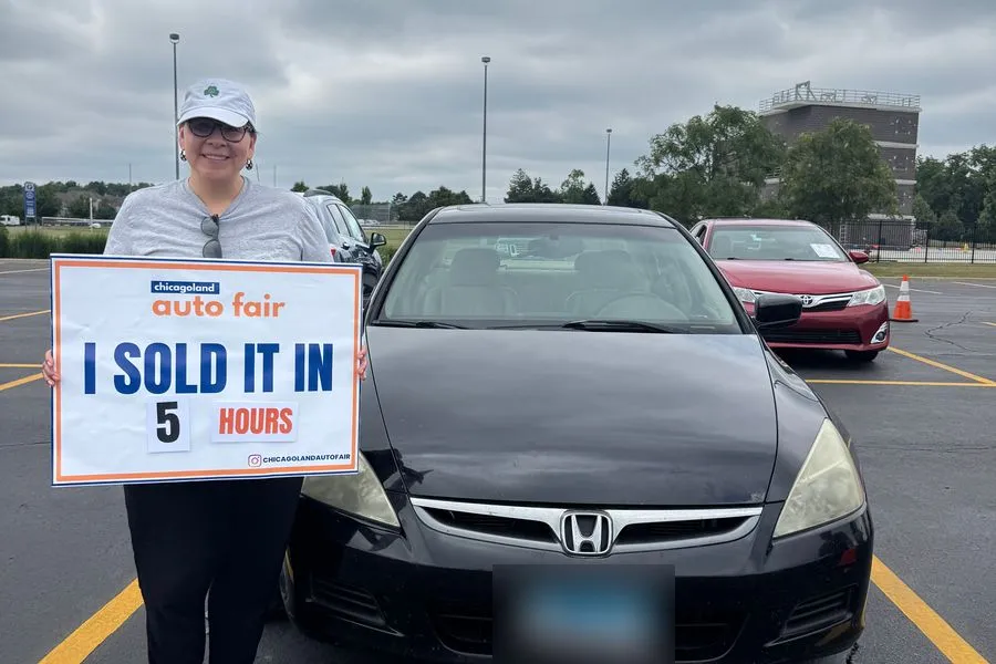 A seller holding an I sold it in 5 hours sign with her Honda Accord